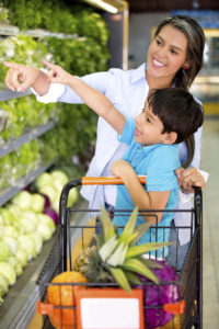 Woman grocery shopping with her kid at the supermarket